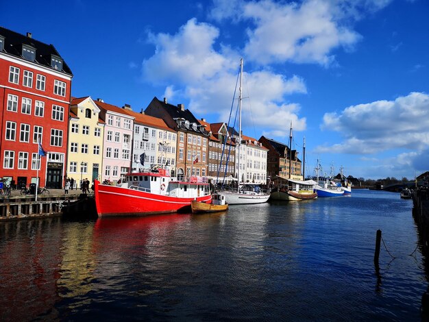 lodzie zaglowe zacumowane na rzece przez budynki na tle nieba 1048944 2072513